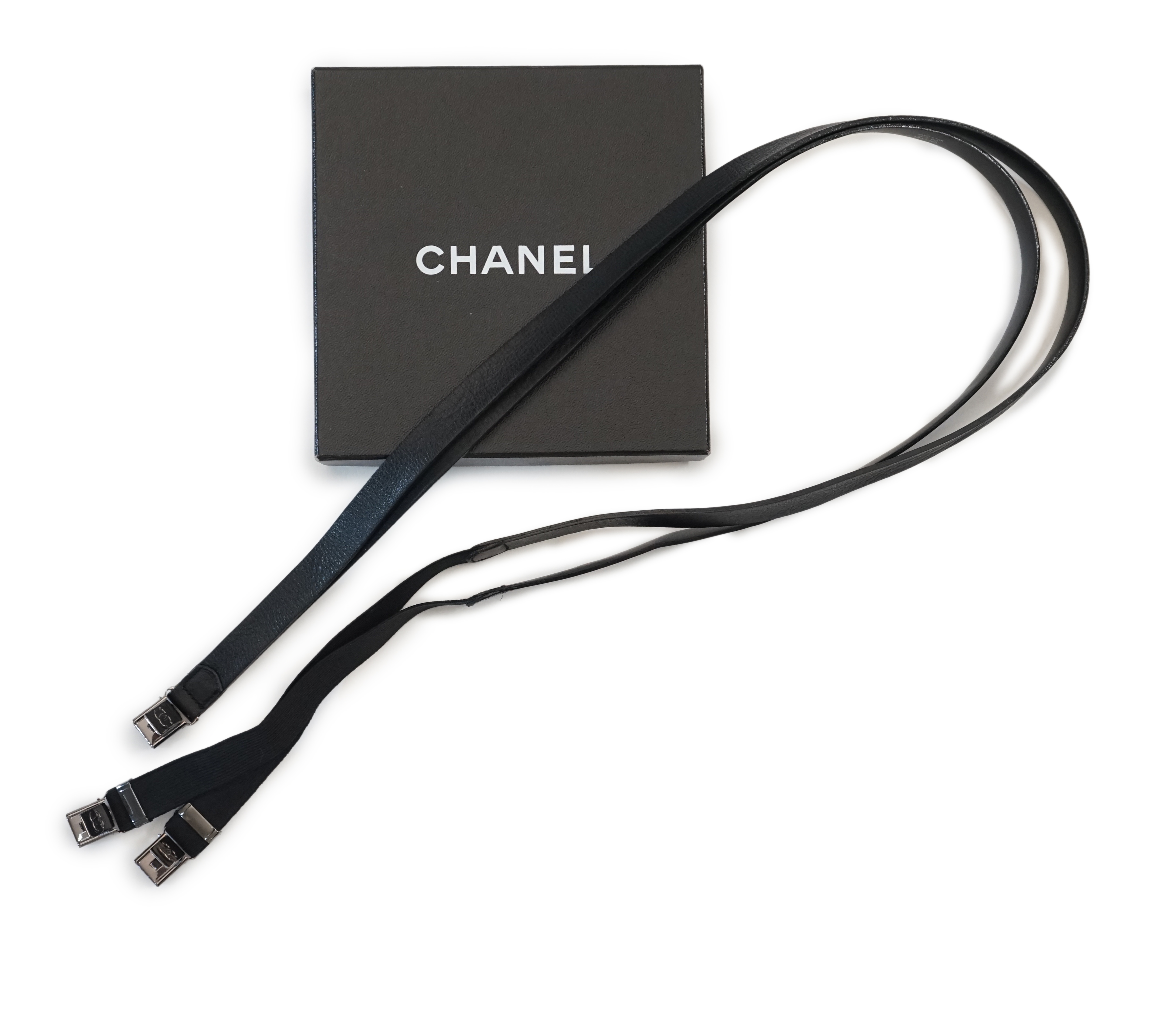 A pair of Chanel black leather one sided braces